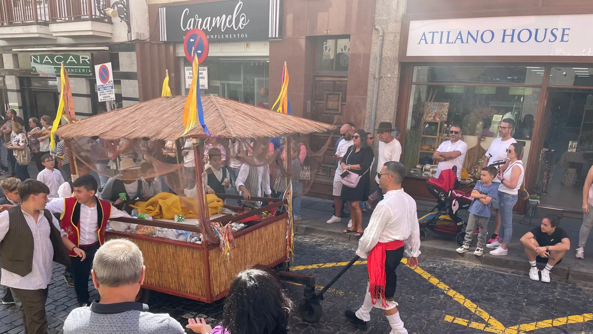 Carreta engalanada y grupo en traje típico en una romería